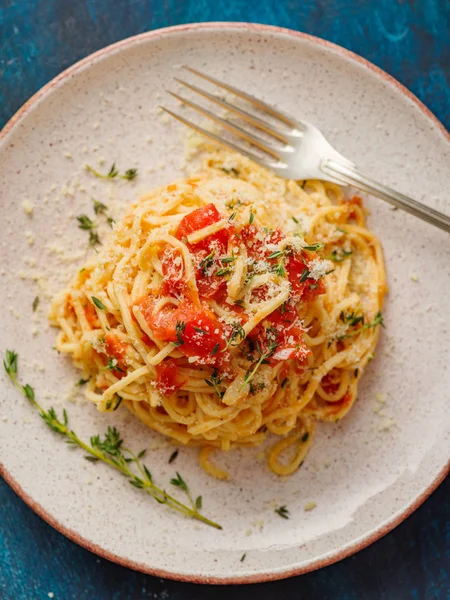 スパゲッティバジルとトマトと青いテーブルの上の皿でタイム トップ ビュー — ストック写真