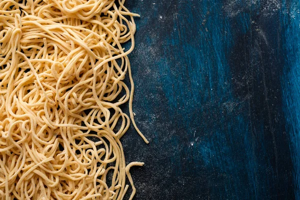 Getrocknete Eiernudeln Rohe Frische Spaghetti Auf Blauem Holzgrund Kopierraum — Stockfoto