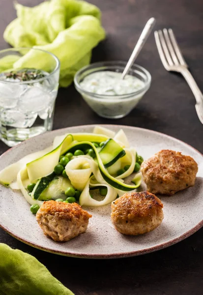 Chicken meat balls with zucchini salad and green peas, with garlic-yogurt sauce