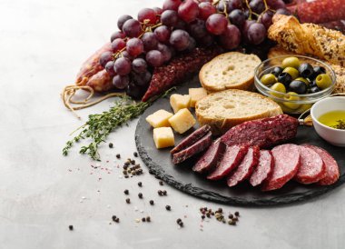 Salam rustik tarzda dilimlenmiş. Salam sosis. Peynir, üzüm ve zeytin ile farklı sosis.