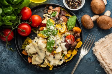Makarna Farfalle mantar, fesleğen, domates ve krema sos ile. Geleneksel İtalyan mutfağı. Akdeniz yemekleri. Üstten görünüm.