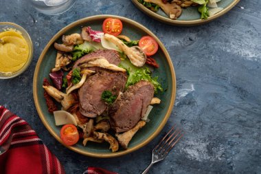 Sıcak sığır istiridye mantar, domates ve yeşillik salatası. Üstten görünüm.