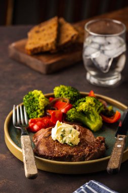 Sarımsak tereyağı ve sebze ızgara sığır eti biftek. Et ızgara dolmalık biber, brokoli ve soğan ile.