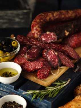 Salam rustik tarzda dilimlenmiş. Salam sosis. Peynir, üzüm ve zeytin ile farklı sosis.