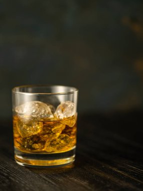 Cam ahşap bir masa üzerinde buzlu viski. Sığ derinlik-in tarla