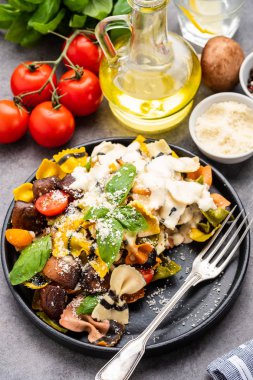 Makarna Farfalle mantar, fesleğen, domates ve krema sos ile. Geleneksel İtalyan mutfağı. Akdeniz yemekleri.