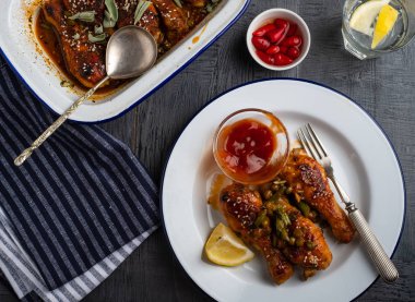 Bezelye, fasulye ve taze otlar ile pişmiş tavuk budu. Tavuk drumsticks lezzetli sause ve yeşillik ile. Üstten görünüm.