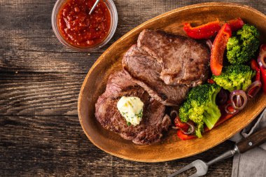Sarımsak tereyağı ve sebze ızgara sığır eti biftek. Et ızgara dolmalık biber, brokoli ve soğan ile.