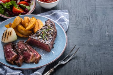 Dilimlenmiş biftek. Biftek orta boy, patates ve kızarmış soğanlı..