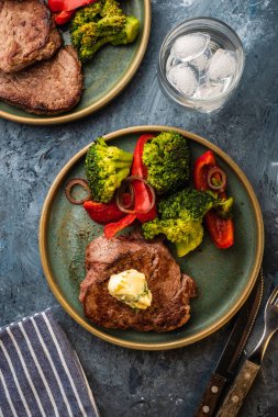 Sarımsak tereyağı ve sebze ızgara sığır eti biftek. Et ızgara dolmalık biber, brokoli ve soğan. Görünümü yukarıdaki.