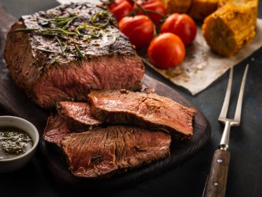 Üzerinde kesme tahtası ızgara sebzeli biftek dilimlenmiş yakın çekim.