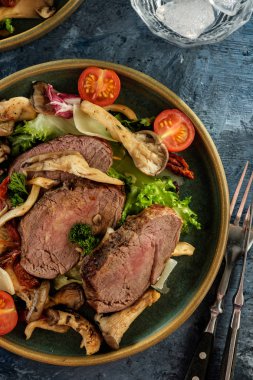 Sıcak sığır istiridye mantar, domates ve yeşillik salatası. Üstten görünüm.