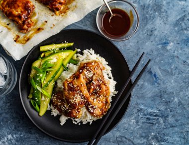 Hoisin Chicken. Traditional Asian cuisine. Chicken with sauce, rice and pickled cucumbers clipart