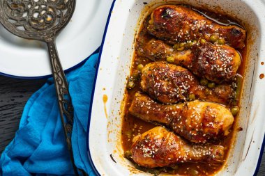 Bezelye, fasulye ve taze otlar ile pişmiş tavuk budu. Tavuk drumsticks lezzetli sause ve yeşillik ile. Üstten görünüm.