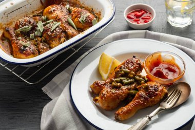 Bezelye, fasulye ve taze otlar ile pişmiş tavuk budu. Tavuk drumsticks lezzetli sause ve yeşillik ile.