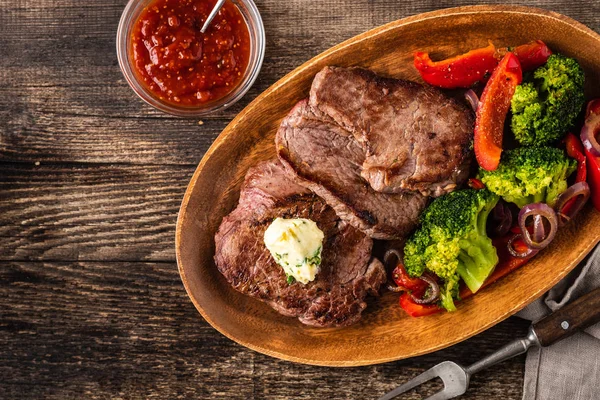 Sarımsak tereyağı ve sebze ızgara sığır eti biftek. Et ızgara dolmalık biber, brokoli ve soğan ile.