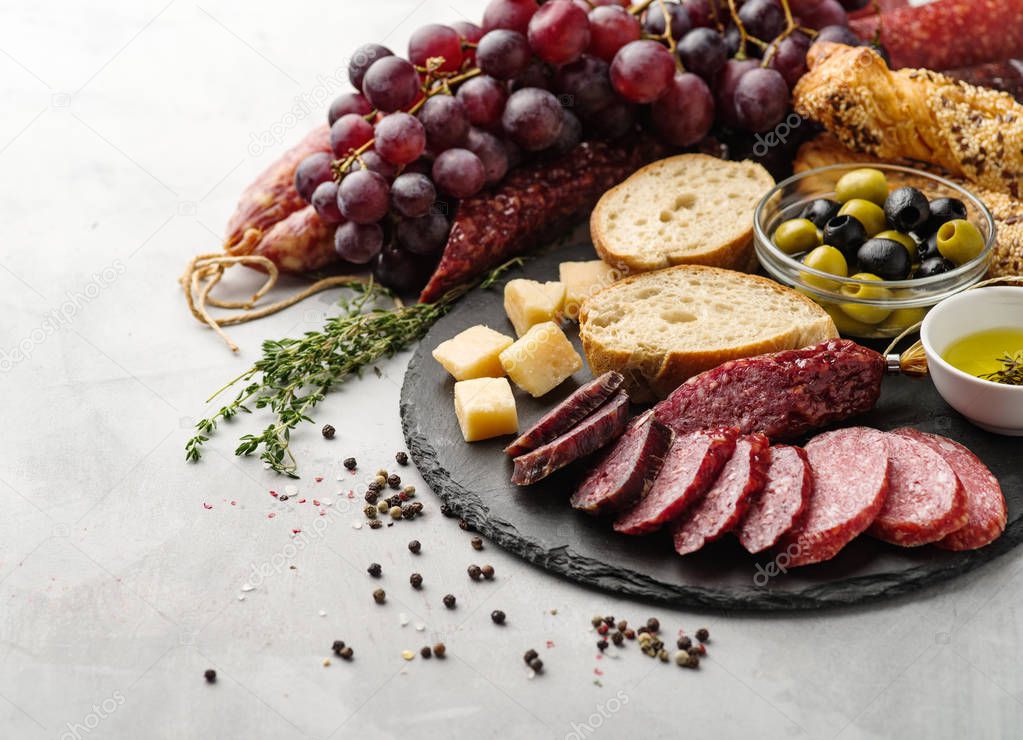 Salami sliced in rustic style. Salami sausage. Different sausages with cheese, grapes and olive.