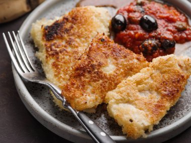 Domates-zeytin soslu ve patatesli kızarmış balık