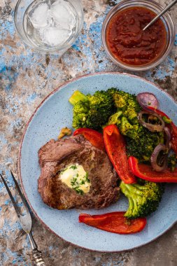Sarımsak tereyağı ve sebze ızgara sığır eti biftek. Et ızgara dolmalık biber, brokoli ve soğan ile.