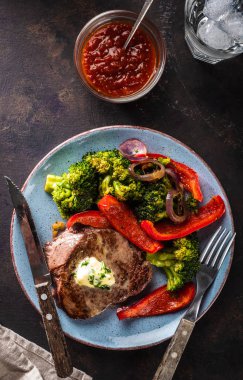 Sarımsak tereyağı ve sebze ızgara sığır eti biftek. Et ızgara dolmalık biber, brokoli ve soğan ile.