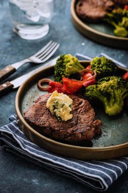 Sarımsak tereyağı ve sebze ızgara sığır eti biftek. Et ızgara dolmalık biber, brokoli ve soğan ile.
