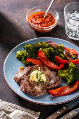 Sarımsak tereyağı ve sebze ızgara sığır eti biftek. Et ızgara dolmalık biber, brokoli ve soğan ile.