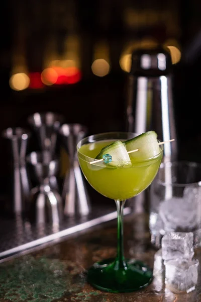 Alcoholic cocktail of green color on a bar counter. Cucumber cocktail.