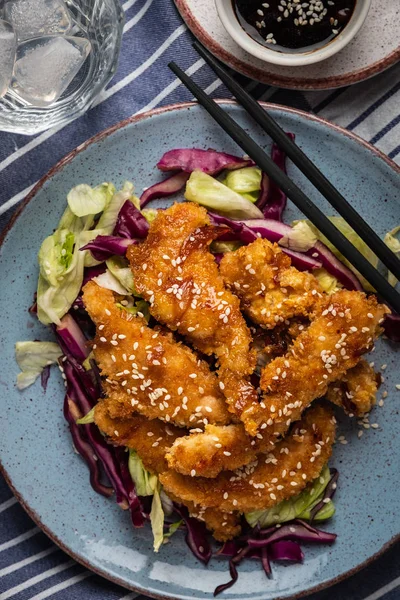 Salad with warm glazing chicken, sprinkled with sesame seeds. Chinese cuisine. Asian culture.