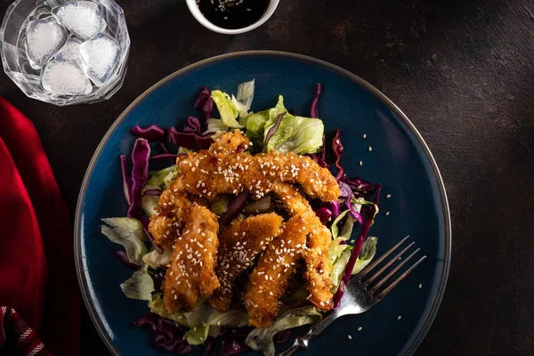 Salad with warm glazing chicken, sprinkled with sesame seeds. Chinese cuisine. Asian culture.