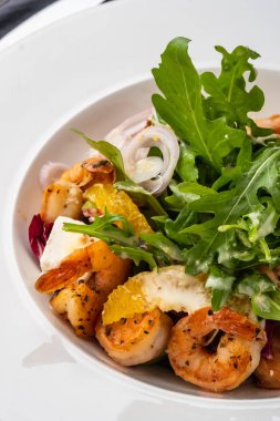 Taze Sicilya salata karides, roka, peynir ve olgun portakal dilimleri ile