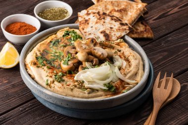 Mantar ve soğan ile geleneksel Akdeniz humus. Kırmızı biber, zeytinyağı, soğan, mantar ve baharatile Klasik Humus.