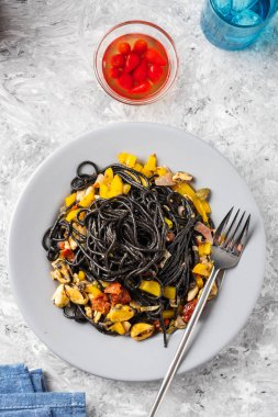 Deniz ürünleri, hamsi, domates ve biber ile siyah makarna. Üstte görüntü.