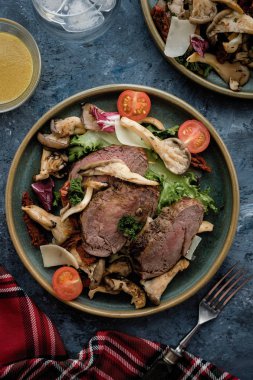 Sıcak sığır istiridye mantar, domates ve yeşillik salatası. Üstten görünüm.