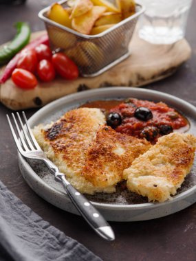 Domates-zeytin soslu ve patatesli kızarmış balık