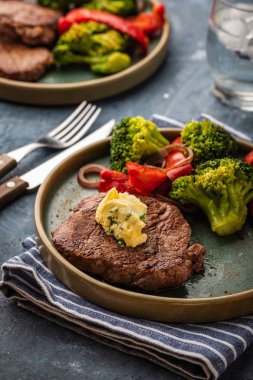 Sarımsak tereyağı ve sebze ızgara sığır eti biftek. Et ızgara dolmalık biber, brokoli ve soğan ile.