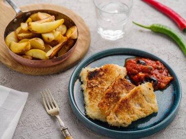 Domates-zeytin soslu ve patatesli kızarmış balık