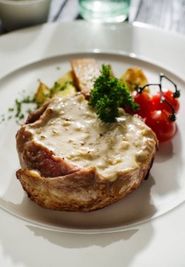 Patates kızartması ve domates ile süslenmiş beyaz mantar soslu domuz eti