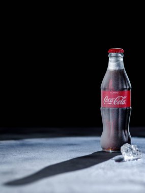 Minsk , Beyaz Rusya - 30 Mart 2019: Karanlık bir arka plan üzerinde coca cola Dondurulmuş şişe. Coca Cola dünya çapında satılan en popüler gazlı meşrubat içecekler