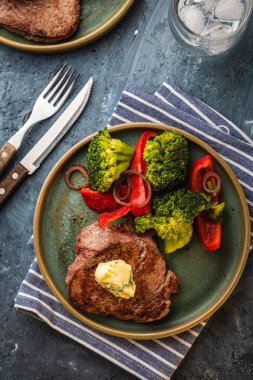 Sarımsak tereyağı ve sebze ızgara sığır eti biftek. Et ızgara dolmalık biber, brokoli ve soğan. Görünümü yukarıdaki.