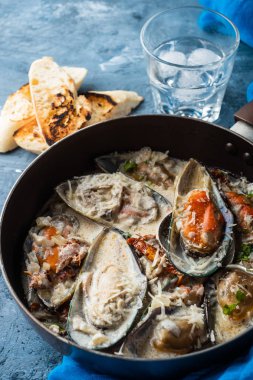 Mavi peynir sosu ve sarımsak baget ile midye