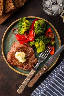 Sarımsak tereyağı ve sebze ızgara sığır eti biftek. Et ızgara dolmalık biber, brokoli ve soğan. Üstten görünüm.