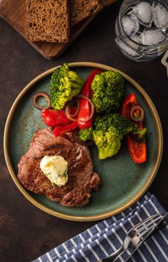 Sarımsak tereyağı ve sebze ızgara sığır eti biftek. Et ızgara dolmalık biber, brokoli ve soğan. Üstten görünüm.
