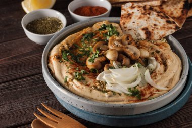 Mantar ve soğan ile geleneksel Akdeniz humus. Kırmızı biber, zeytinyağı, soğan, mantar ve baharatile Klasik Humus.