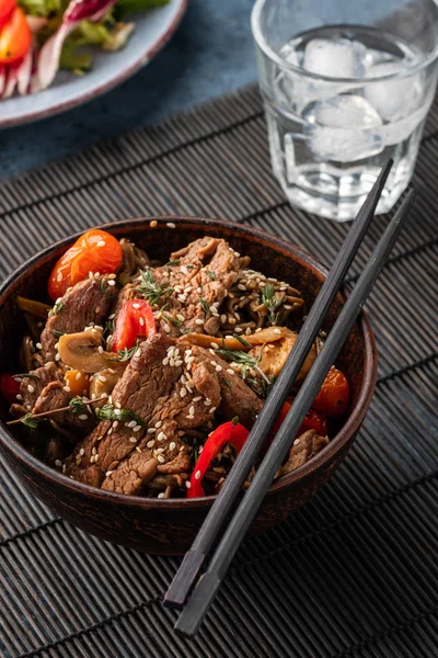 Soba noodles with beef, mushrooms, cherry tomato and sweet peppers. Asian cuisine.