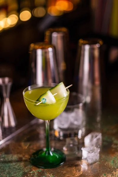 Alcoholic cocktail of green color on a bar counter. Cucumber cocktail.