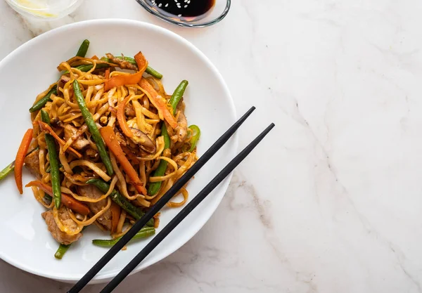 Teriyaki soslu domuz eti ile Asya erişte, yeşil fasulye, havuç ve shiitake mantar ile. Üstte görüntü.