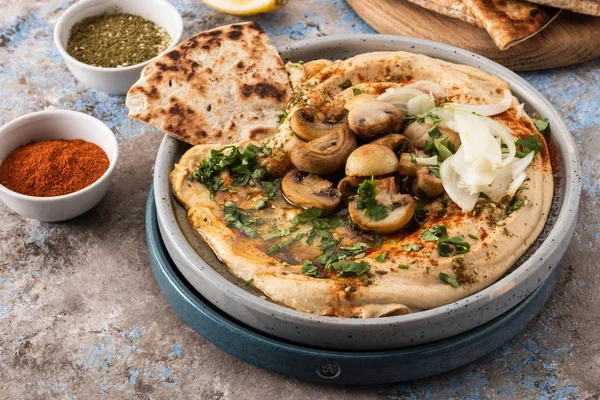 Mantar ve soğan ile geleneksel Akdeniz humus. Kırmızı biber, zeytinyağı, soğan, mantar ve baharatile Klasik Humus.