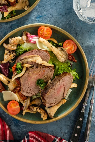 Sıcak sığır istiridye mantar, domates ve yeşillik salatası. Üstten görünüm.