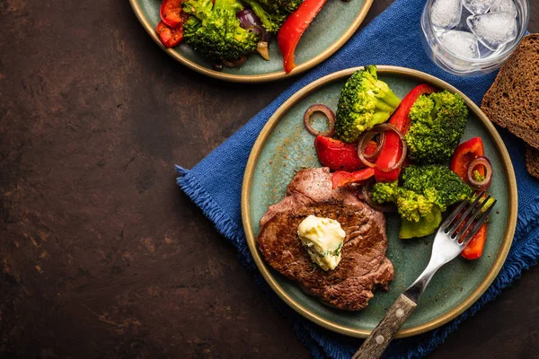 Sarımsak tereyağı ve sebze ızgara sığır eti biftek. Et ızgara dolmalık biber, brokoli ve soğan. Üstten görünüm.