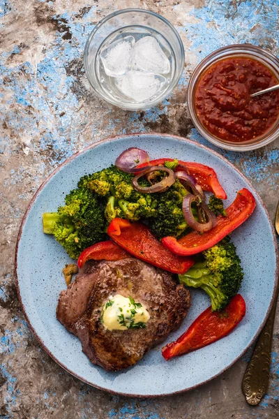 Sarımsak tereyağı ve sebze ızgara sığır eti biftek. Et ızgara dolmalık biber, brokoli ve soğan ile.